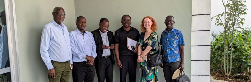 six people standing together and smiling outside of a medical office